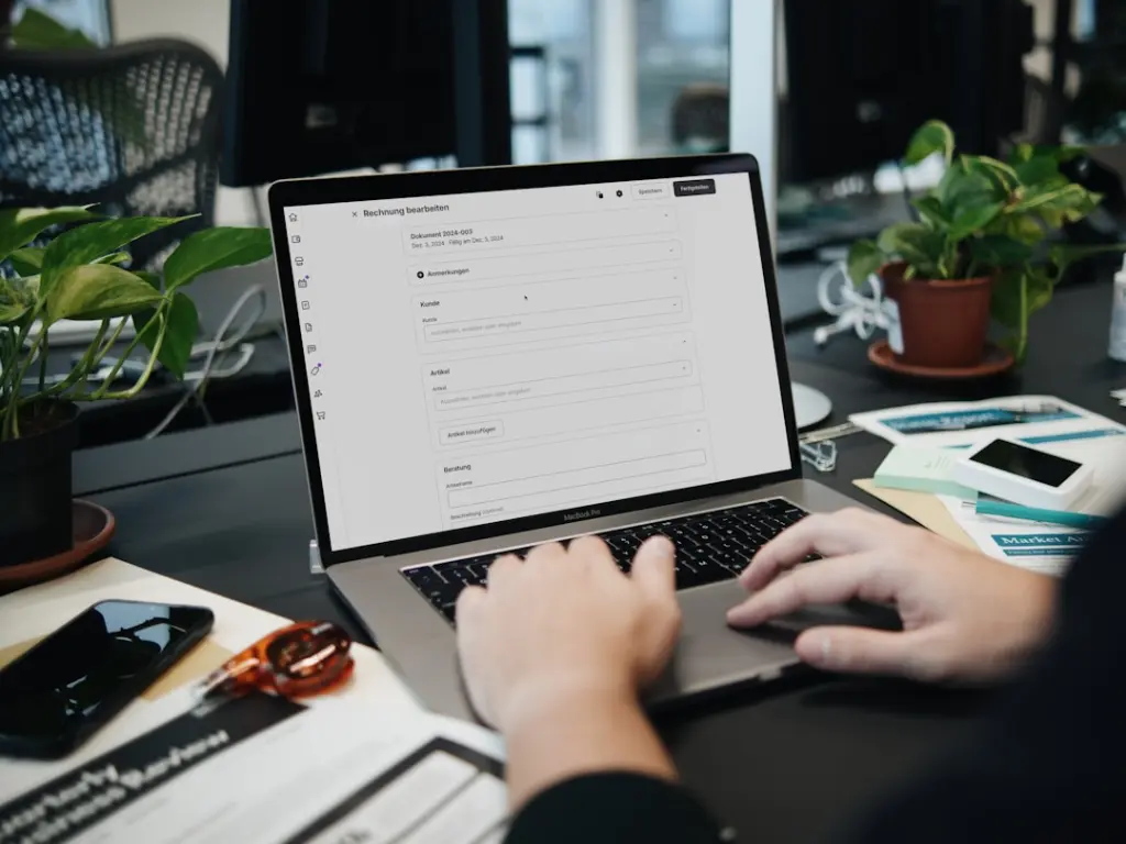 A person typing on a laptop on a desk by SumUp